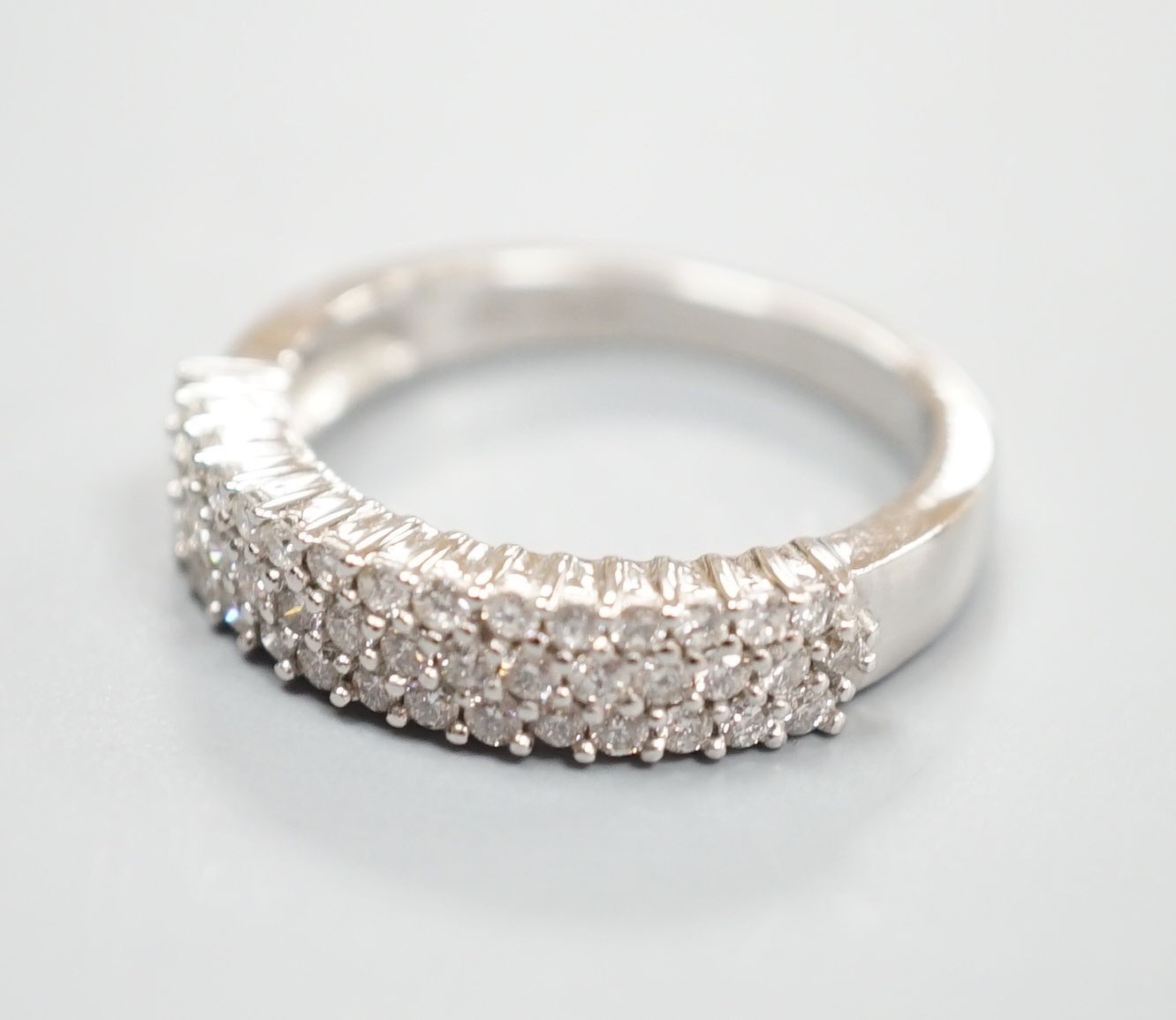 A modern 18ct white gold and three row diamond chip set half hoop ring, size K/L, gross weight 4.2 grams